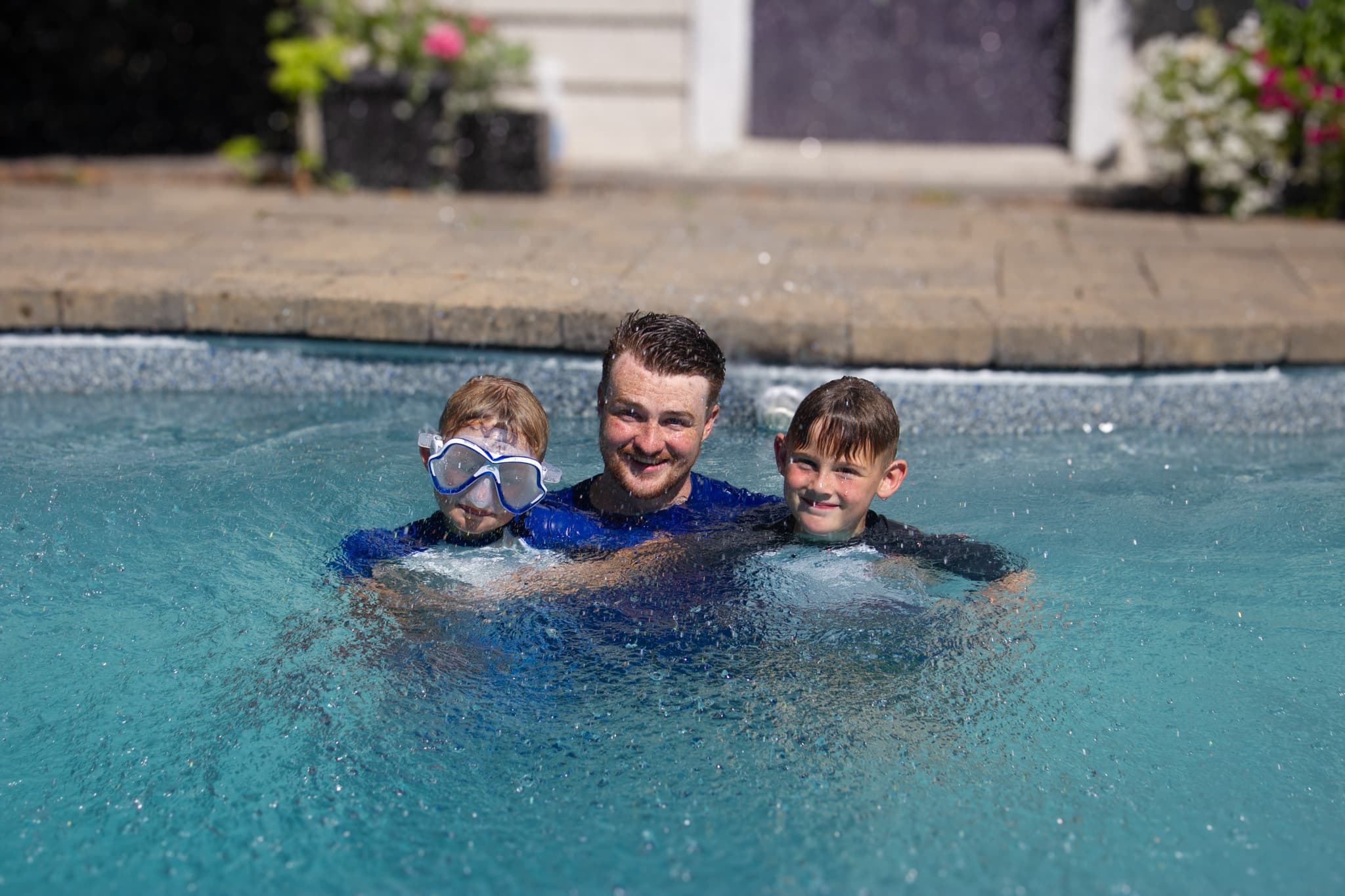 Instructor posing with 2 swimmers for a photo.